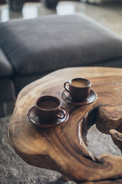 Zwei braune Keramiktassen auf einem Holztisch